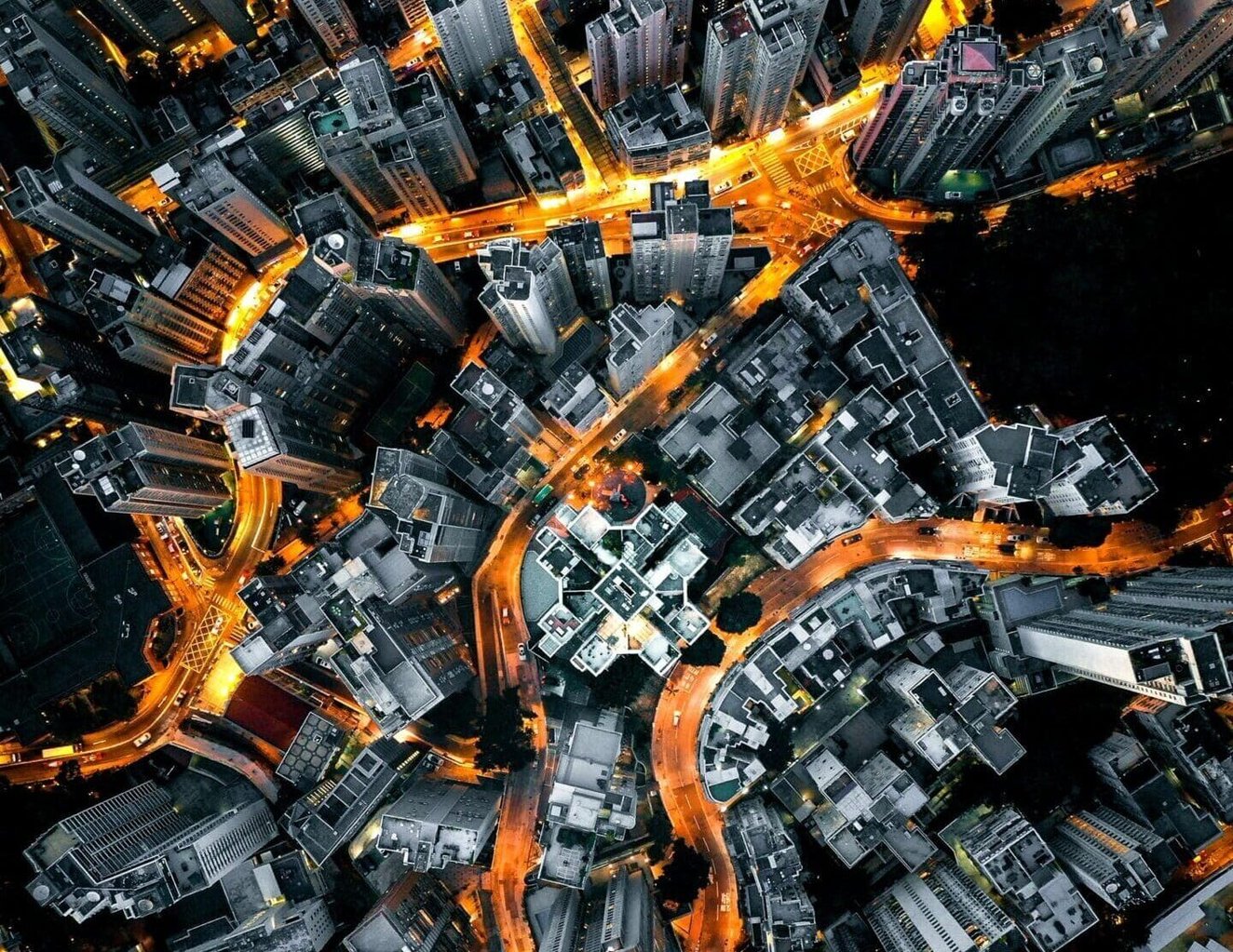 Birdseye shot of a city at night with streets lit up in orange.